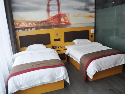 2 camas en una habitación de hotel con un cuadro en la pared en Thank Inn Chain Hotel Shandong linyi hedong hot spring resort, en Linyi