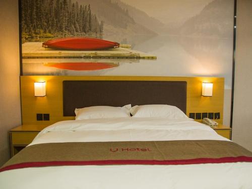 1 cama grande en una habitación de hotel con 2 lámparas en Thank Inn Plus Hotel jingxi shangrao economic development zone jingke avenue, en Shangrao