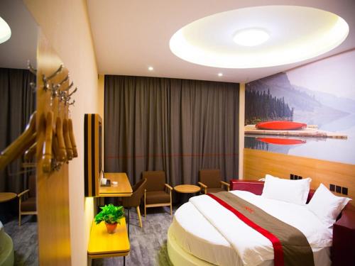 a hotel room with a bed and a table and chairs at Thank Inn Chain Hotel gansu tianshui maiji district xihuang avenue in Tianshui