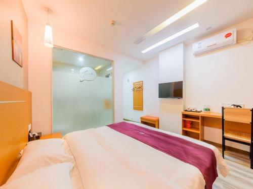 a bedroom with a large bed and a kitchen at Thank Inn Chain Hotel Guangdong Guangzhou Baiyun International Airport in Guangzhou