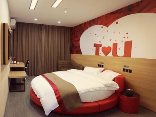 a bedroom with a bed with a heart sign on the wall at Thank Inn Chain Hotel Jiangsu Suzhou Taihu Lake Dongshan Town in Suzhou