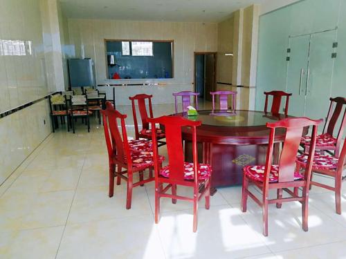- une table à manger rouge avec des chaises et une télévision dans l'établissement Thank Inn Chain Hotel hebei zhangjiakou wanquan county kongjiazhuang bus station, à Zhangjiakou