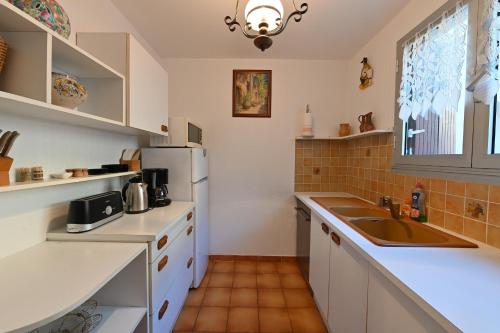 une cuisine avec un évier et un réfrigérateur dans l'établissement superbe duplex bord de mer, à Port-Vendres
