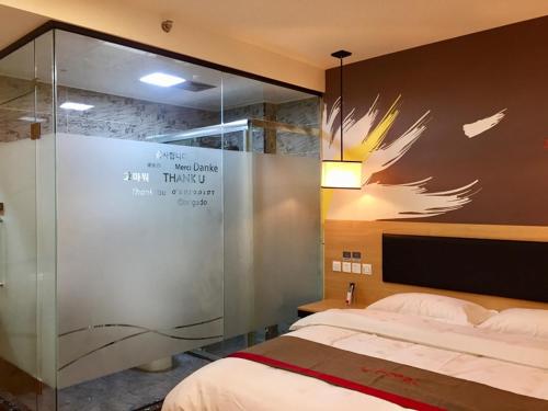 1 dormitorio con 1 cama y pared de cristal en Thank Inn Chain Hotel fujian quanzhou fengze district donghai street en Quanzhou