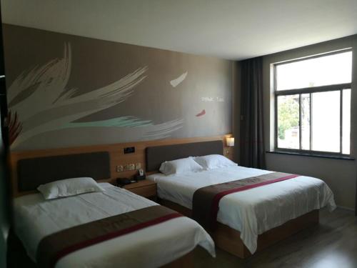 a hotel room with two beds and a wall with butterflies at Thank Inn Chain Hotel Shandong jining zoucheng tang town yingbin avenue in Jining