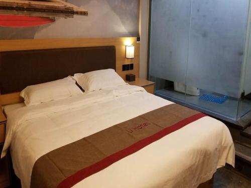 uma cama grande num quarto de hotel em Thank Inn Chain Hotel jiangxi ganzhou zhanggong district civilization avenue em Ganzhou