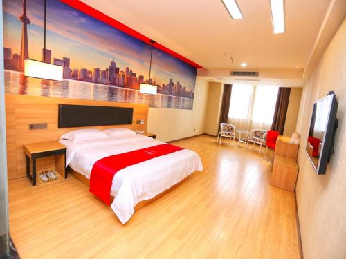 una camera d'albergo con un letto e un dipinto sul muro di Thank Inn Chain Hotel hubei tianmen city renxin international plaza a Tianmen
