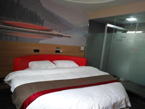 a bedroom with a large bed with a red headboard at Thank Inn Chain Hotel Jiangsu Taizhou West Passenger Station Jianhang Store in Taizhou