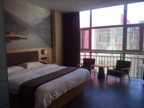 ein Hotelzimmer mit einem Bett und einem Tisch mit Stühlen in der Unterkunft Thank Inn Chain Hotel hebei cangzhou botou city anshun street in Cangzhou
