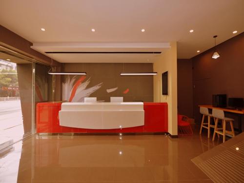 salon z czerwono-białą kanapą w obiekcie Thank Inn Chain Hotel sichuan ziyang yanjiang district walmart w mieście Ziyang