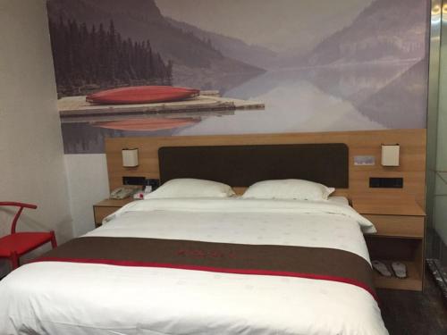 ein Schlafzimmer mit einem großen Bett und einem Gemälde an der Wand in der Unterkunft Thank Inn Chain Hotel Fujian Quanzhou Anxi County Yongan Road in Quanzhou