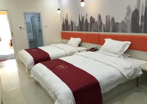 two beds in a hotel room with a painting on the wall at Thank Inn Chain Hotel jiangxi fuzhou linchuan district new no.3 middle school in Fuzhou