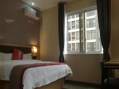 a hotel room with a bed and a window at Thank Inn Chain Hotel guangxi liuzhou wal-mart jinfudi in Liuzhou