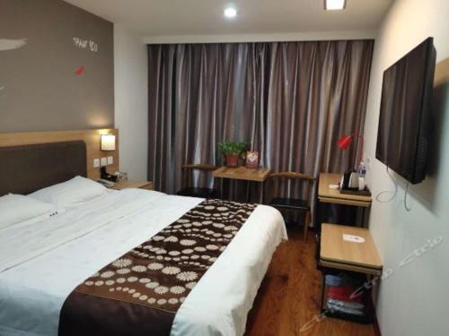 Habitación de hotel con cama y TV de pantalla plana. en Thank Inn Chain Hotel henan luohe liaohe road denis square, en Luohe