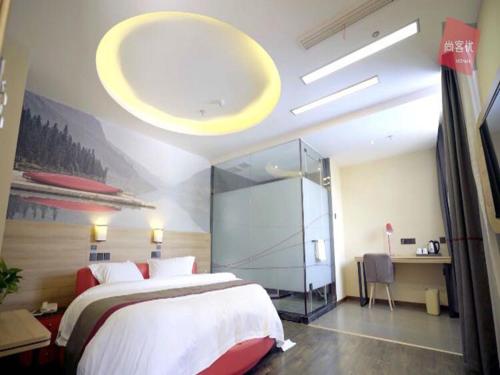 a bedroom with a large bed and a glass wall at Thank Inn Chain Hotel anhui bengbu huaishang district mohekou county in Bengbu