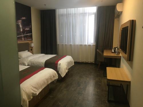 a hotel room with two beds and a desk and a television at Thank Inn Chain Hotel jiangsu suzhou changshu city zhitang in Gujiashuigou