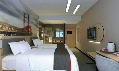 um quarto de hotel com uma grande cama branca e uma secretária em Thank Inn Chain Hotel henan luoyang mengjin county huimeng avenue bilingual school em Luoyang