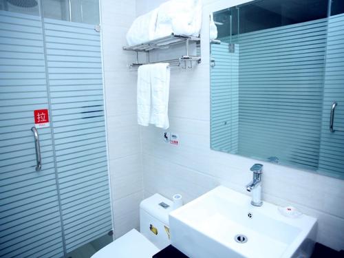 ein Badezimmer mit einem Waschbecken, einem Spiegel und einem WC in der Unterkunft Thank Inn Chain Hotel henan luoyang high-tech district jiudu west road zhoushan station in Luoyang