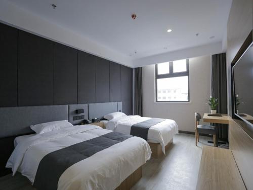 Thank Inn Plus Hotel Shandong Qingdao Licang Wan Nianquan Road tesisinde bir odada yatak veya yataklar