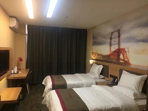 ein Hotelzimmer mit 2 Betten und einem TV in der Unterkunft Thank Inn Chain Hotel inner mongolia bayannaoer urat qianqi huifeng square in Xishanzui