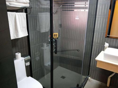 a bathroom with a glass shower with a toilet at Thank Inn Chain Hotel anhui fuyang funan county department store in Fuyang