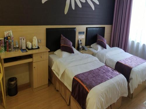 Cette chambre comprend deux lits et un bureau. dans l'établissement Thank Inn Chain Hotel guizhou south prefecture longli county high-speed railway station, à Longli