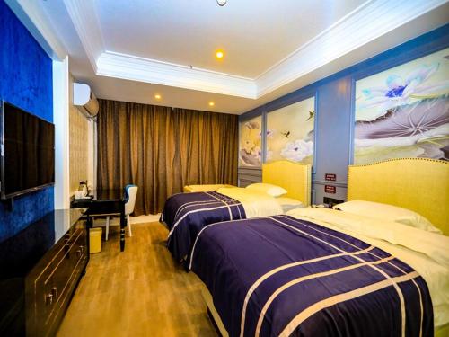 a hotel room with two beds and a desk at Thank Inn Chain Hotel Jiangsu Yancheng dongtai Jianggang town in Cuiguangshan