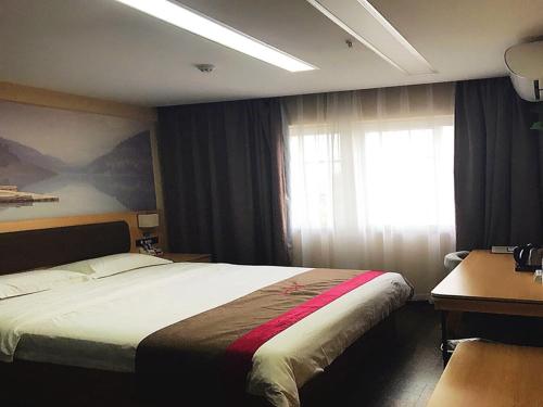 a hotel room with a bed and a window at Thank Inn Chain Hotel anhui fuyang funan county government in Fuyang