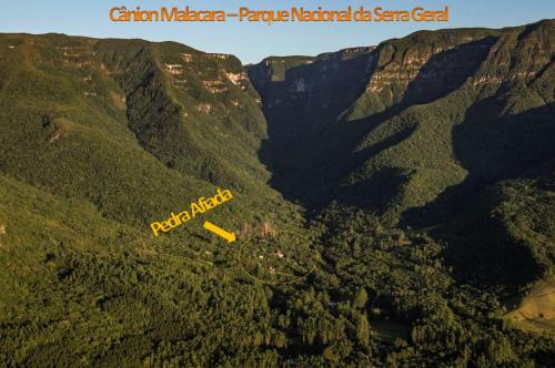 an aerial view of the grand canyon with a yellow sign at Refúgio Ecológico Pedra Afiada in Praia Grande