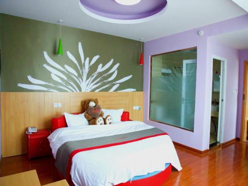 a bedroom with a large bed with two teddy bears on it at Thank Inn Chain Hotel henan kaifeng jinming district xinghuaying town government in Kaifeng