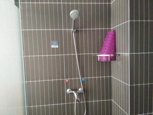 a shower with a pink sponge in a bathroom at Thank Inn Chain Hotel Shandong zaozhuang central district ginza mall in Zaozhuang
