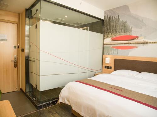 a bedroom with a bed and a large glass wall at Thank Inn Chain Hotel shanxi jinzhong yuci ditrict shuncheng west street in Jinzhong