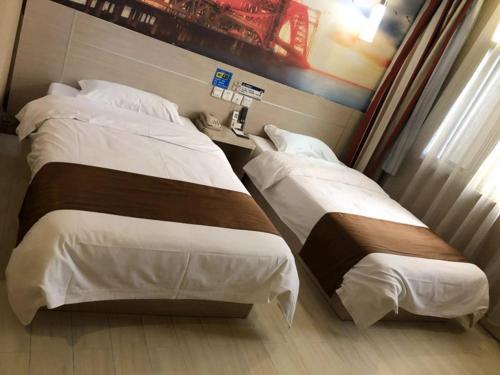 BinzhouにあるThank Inn Chain Hotel Shandong Binzhou Bohai 5th Roadのベッド2台と窓が備わるホテルルームです。