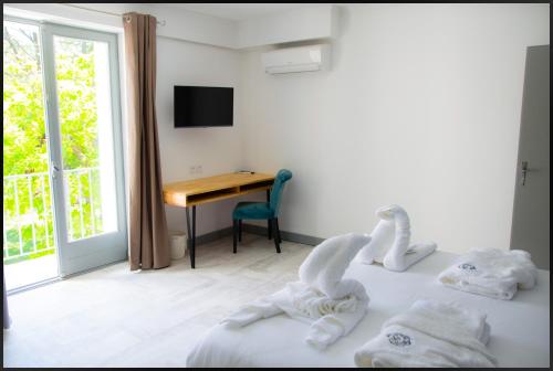 um quarto com uma secretária e uma cama com toalhas em La Redoniere em Romans-sur-Isère