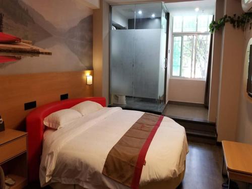 um quarto com uma cama grande e uma janela grande em Thank Inn Chain Hotel jiangxi ganzhou zhanggong district civilization avenue em Ganzhou