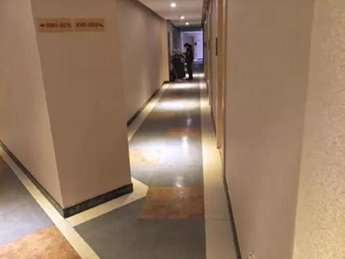 een gang in een gebouw met een lange gang bij Thank Inn Chain Hotel Jiangsu suzhou kunshan foxconn in Suzhou