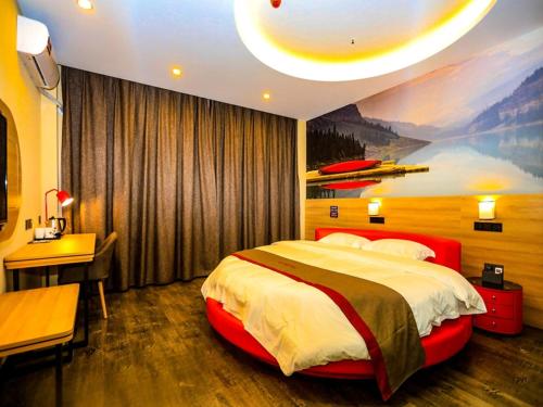 a bedroom with a large bed with a painting on the wall at Thank Inn Chain Hotel Jiangsu Yancheng dongtai Jianggang town in Cuiguangshan
