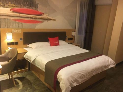 a bedroom with a large bed with a red pillow at Thank Inn Chain Hotel sichuan guang'an yuechi rongxinyue city in Guang'an