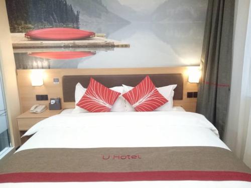 a bed with red and white pillows in a hotel room at Thank Inn Chain Hotel shandong binzhou bincheng district binbei in Binzhou