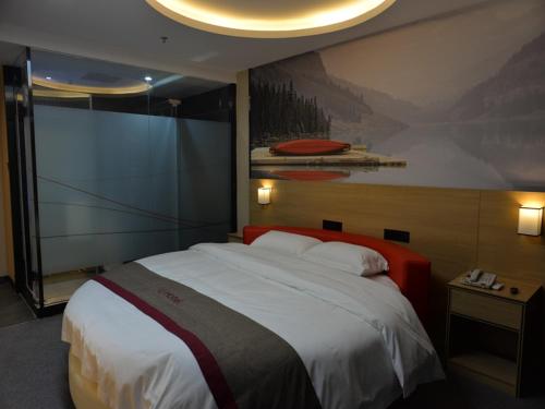 a bedroom with a large bed and a painting on the wall at Thank Inn Chain Hotel sichuan mianyang yuzhong road airport in Mianyang