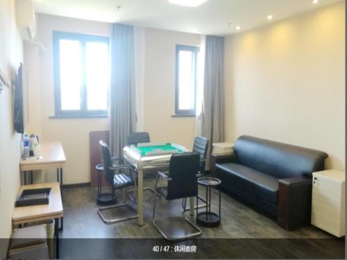a room with a couch and a table and chairs at Thank Inn Chain Hotel Shanghai jinshan, jinshan new town in Nanhui