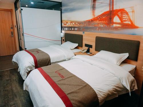two beds in a hotel room with a large screen at Thank Inn Chain Hotel Jiangsu yancheng pavilion lakes open road in Yancheng