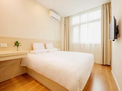 uma grande cama branca num quarto com uma janela em Thank Inn Chain Hotel henan jiaozuo liberated district democracy road em Jiaozuo
