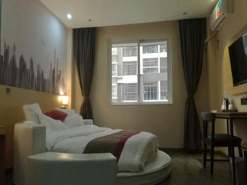 Un dormitorio con una cama grande y una ventana en Thank Inn Chain Hotel guangxi liuzhou wal-mart jinfudi, en Liuzhou