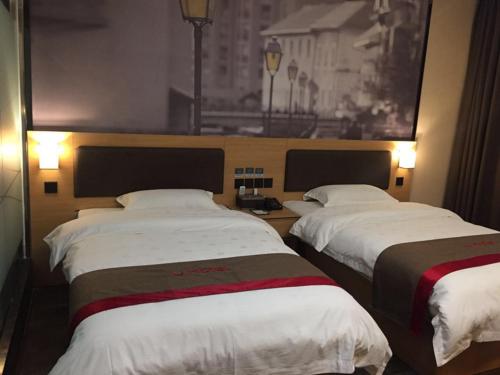 two beds in a hotel room with white sheets at Thank Inn Chain Hotel guizhou zunyi chishui city red army avenue jinshui bay in Chishui