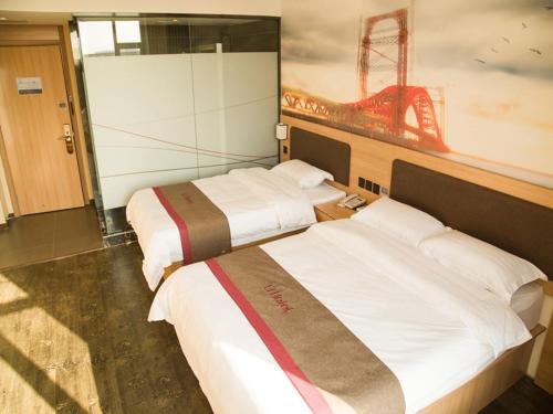 two beds in a room with a painting of a ballpark at Thank Inn Chain Hotel shanxi jinzhong yuci ditrict shuncheng west street in Jinzhong