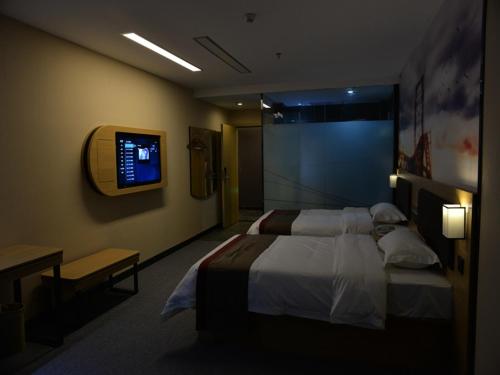 a bedroom with a bed and a tv on the wall at Thank Inn Chain Hotel sichuan mianyang yuzhong road airport in Mianyang
