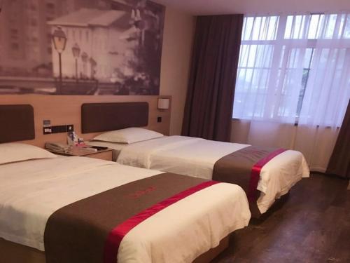 阜陽にあるThank Inn Chain Hotel anhui fuyang funan county governmentのベッド2台と窓が備わるホテルルームです。