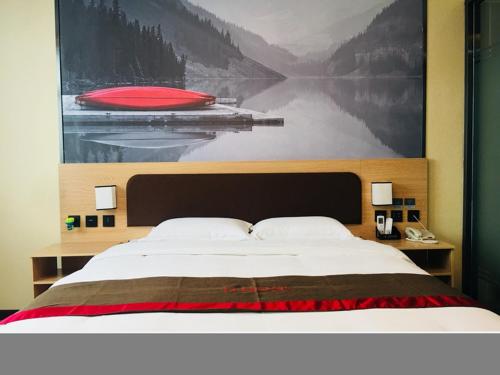 1 dormitorio con 1 cama y una gran pintura en la pared en Thank Inn Chain Hotel hebei baoding qingyuan district vocational education center, en Baoding