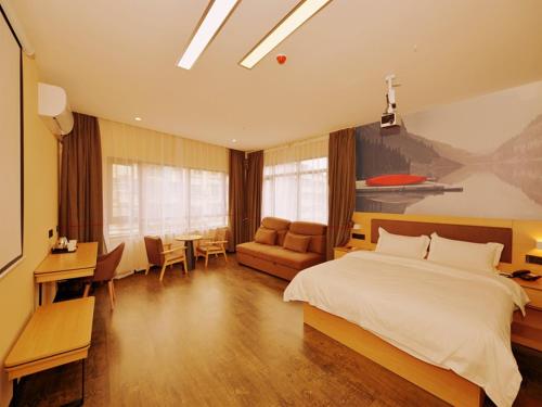 a bedroom with a bed and a table and chairs at Thank Inn Chain Hotel sichuan ziyang yanjiang district walmart in Ziyang